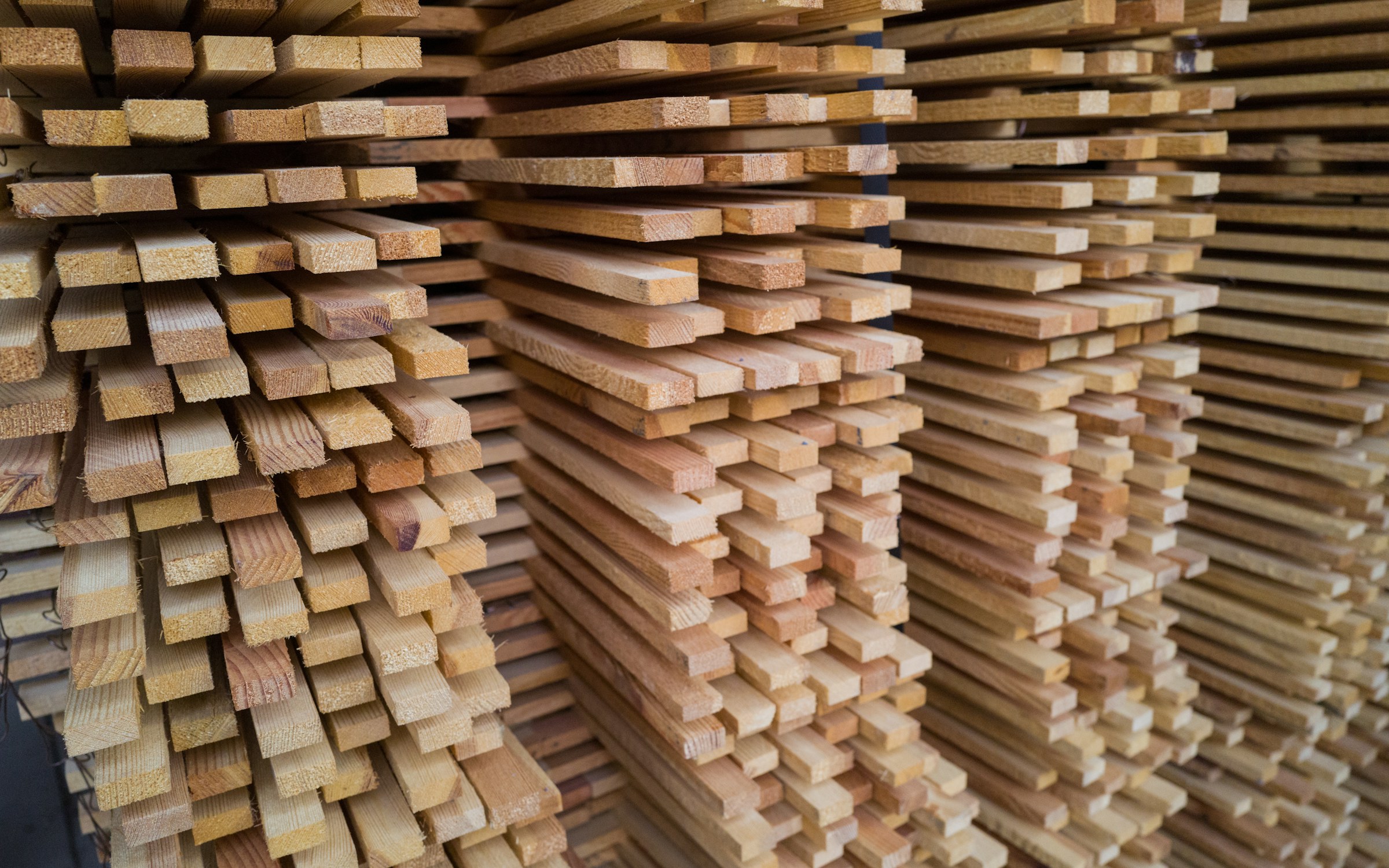 Steel coils and lengths of timber stacked in a building materials yard